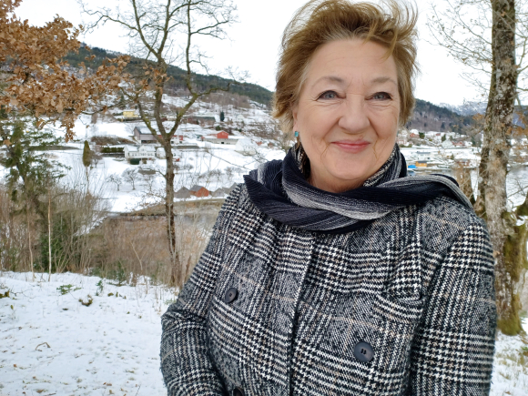 FJELLA HEIME: Bustadpolitikken i Oslo var sterkt medverkande til at Arnhild Litlere valde å flytte heim til Strandebarm for ti år sidan. Og uansett kor mange millionar du har i hovudstaden, får du aldri kjøpt utsikta til Gygra-fjellet og Hardangerfjorden. Foto: Heidi Molstad Andresen / NPK